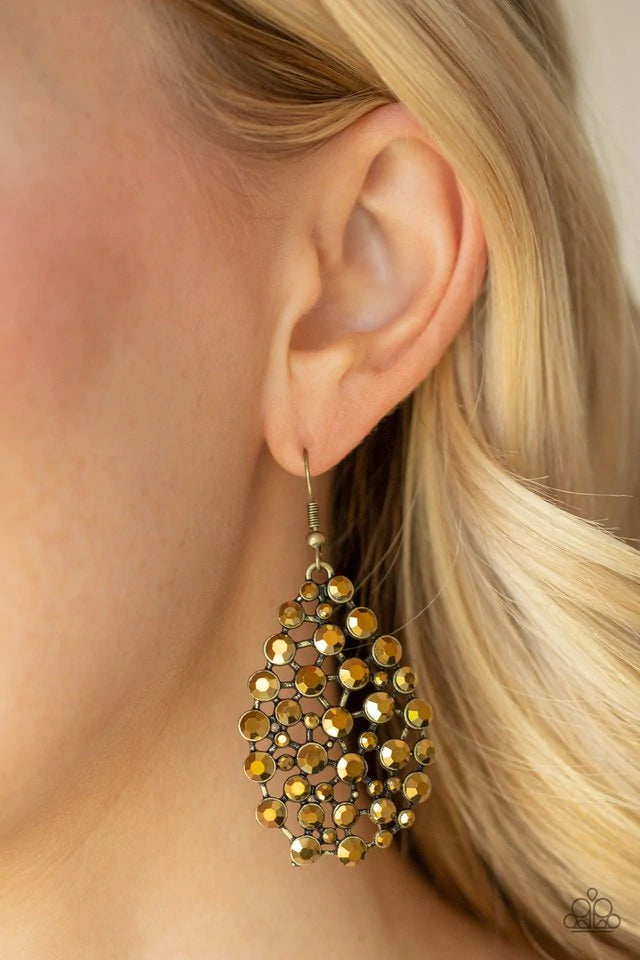 An explosion of glittery aurum rhinestones coalesces into a blinding teardrop frame for a statement-making look. Earring attaches to a standard fishhook fitting. Sold as one pair of earrings.