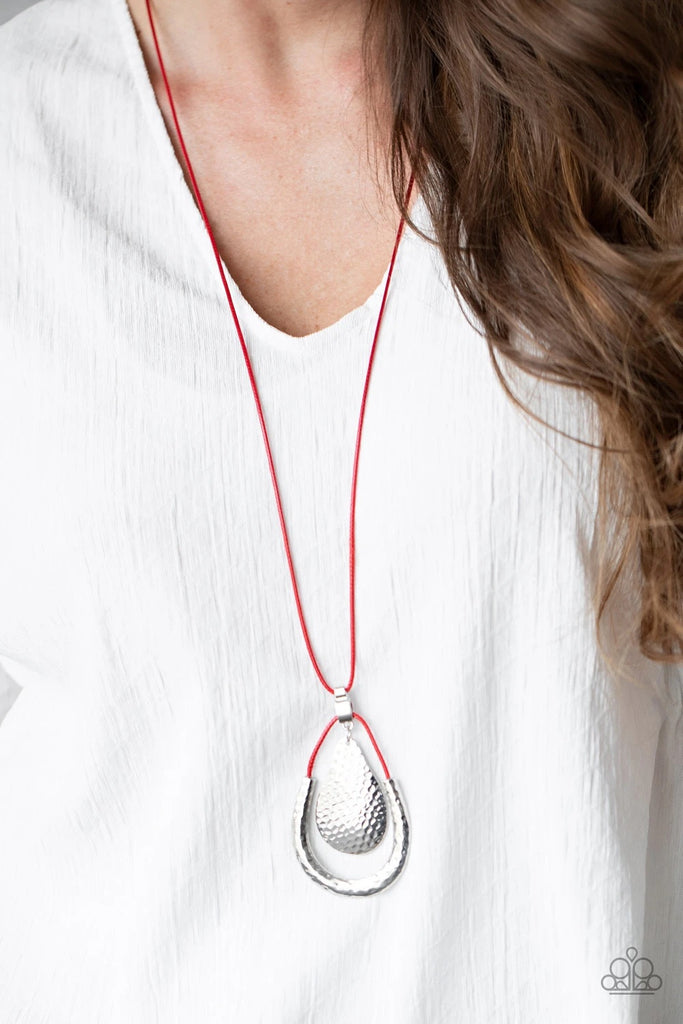 Attached to a shiny silver fitting, a hammered silver teardrop swings from the top of a shiny red cord pendant featuring a hammered silver accent. The stacked pendants swing from the bottom of a lengthened piece of red cord for a colorfully trendy look. Features an adjustable clasp closure.  Sold as one individual necklace. Includes one pair of matching earrings.