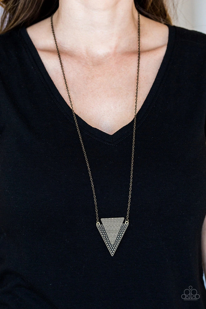 Stamped and studded in indigenous inspired textures, a stacked triangular pendant swings from the bottom of an elongated brass chain for a trendy tribal look. Features an adjustable clasp closure.  Sold as one individual necklace. Includes one pair of matching earrings.