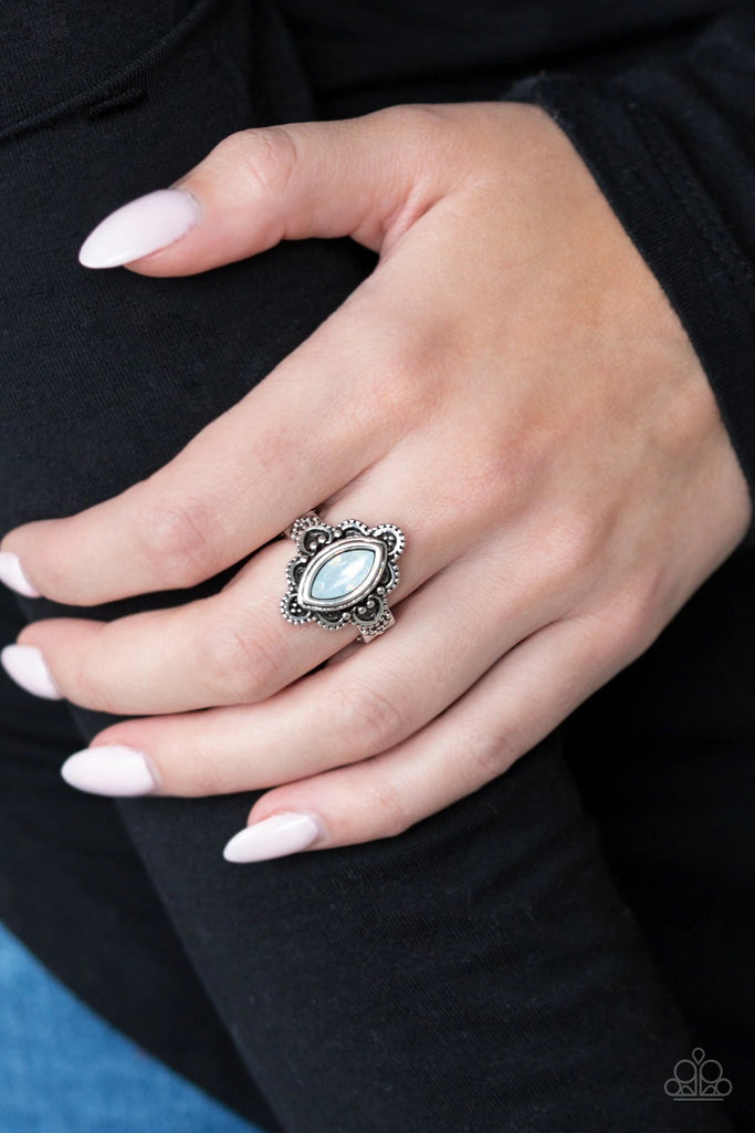 An opalescent white gem is pressed into a scalloped silver frame radiating with shiny silver studs, creating a whimsical frame atop the finger. Features a dainty stretchy band for a flexible fit.  Sold as one individual ring.