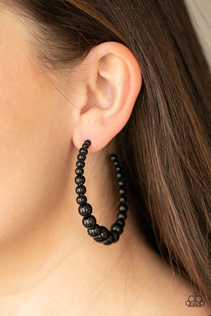 Gradually increasing in size at the center, a classic row of polished black beads are threaded along an oversized hoop for a posh finish. Earring attaches to a standard post fitting. Hoop measures approximately 2 1/4" in diameter.  Sold as one pair of hoop earrings.  