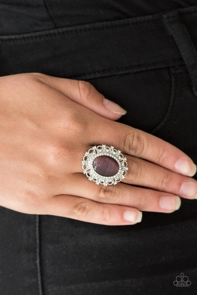 Encrusted in dainty white rhinestones, a frilly silver frame spins around a glowing purple moonstone center for a regal look. Features a stretchy band for a flexible fit.  Sold as one individual ring.