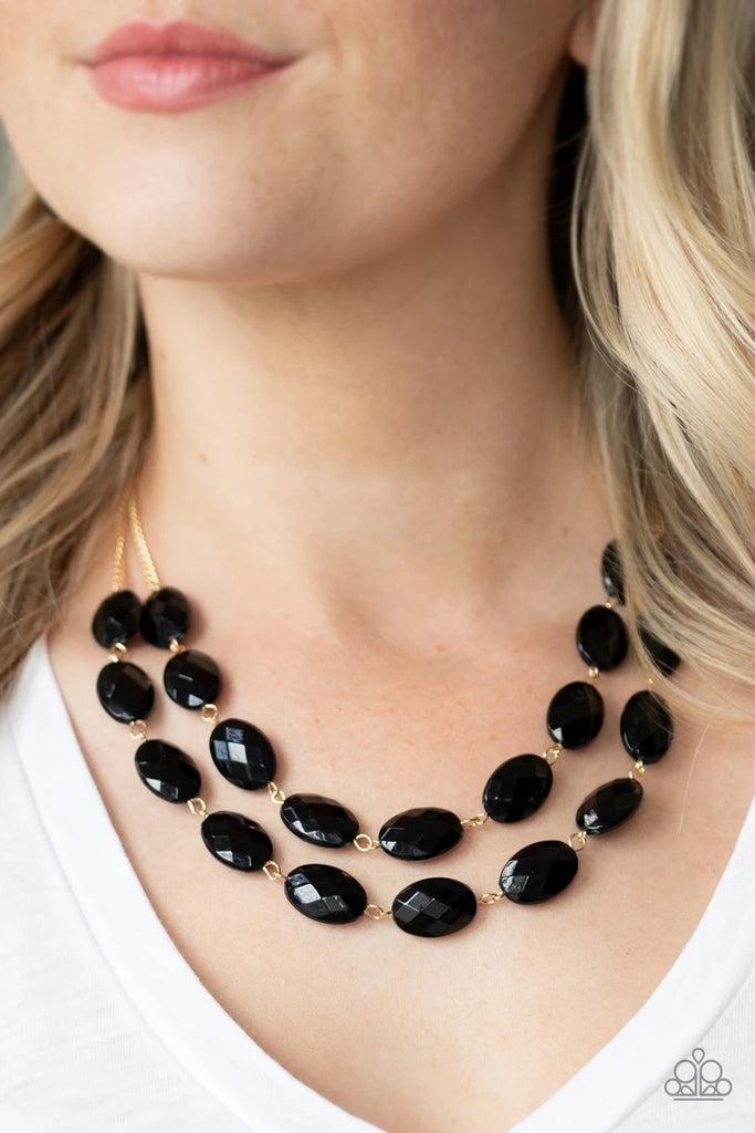 Attached to dainty gold chains, oval black beads delicately link into colorful rows below the collar, adding a powerful splash of color to any outfit. Features an adjustable clasp closure.  Sold as one individual necklace. Includes one pair of matching earrings.