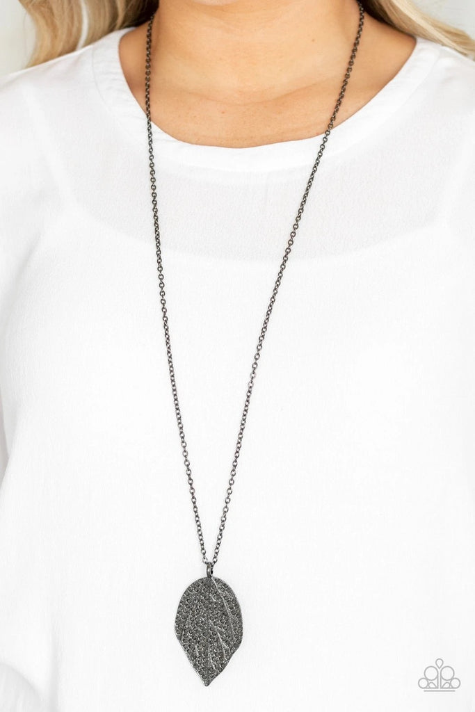 Featuring lifelike patterns, a hematite rhinestone encrusted gunmetal leaf swings from the bottom of a lengthened gunmetal chain, creating an edgy pendant. Features an adjustable clasp closure.  Sold as one individual necklace. Includes one pair of matching earrings.