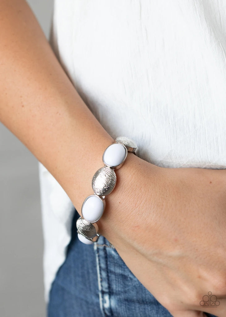 Bubbly white beaded frames and textured silver caps alternate along stretchy bands around the wrist, adding a colorful pop of color.  Sold as one individual bracelet.