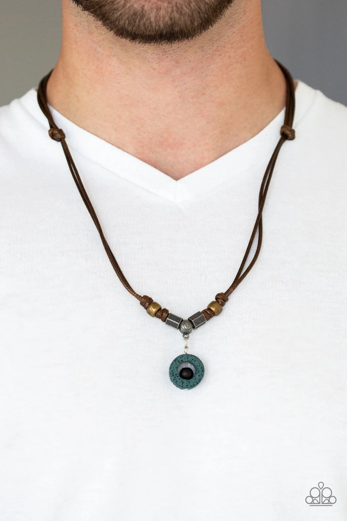 A collection of brass and silver accents are knotted in place below the collar. A black wooden bead is threaded along a rod in the center of a green lava rock pendant for a seasonal flair. Features an adjustable sliding knot closure.  Sold as one individual necklace.