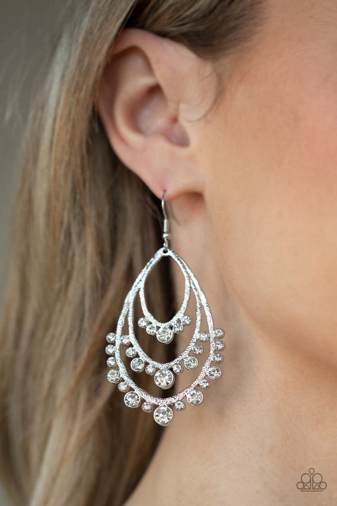 A gorgeous collection of glassy white rhinestones drip from the bottom of a tiered silver frame, coalescing into a dazzling statement piece. Earring attaches to a standard fishhook fitting.  Sold as one pair of earrings.