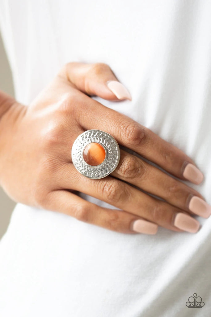 A glowing orange moonstone is pressed into a large silver frame embossed in a leafy pattern for a whimsical look. Features a stretchy band for a flexible fit.  Sold as one individual ring.