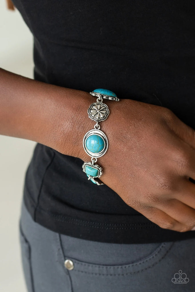 Featuring refreshing turquoise stone centers, a collection of antiqued silver frames link with a decorative floral charm around the wrist for a seasonal flair. Features an adjustable clasp closure.  Sold as one individual bracelet.