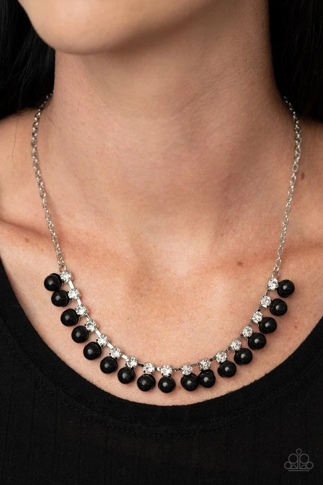 Crowned in glassy white rhinestones, a timeless row of polished black beads delicately link below the collar for a fabulously refined look. Features an adjustable clasp closure.  Sold as one individual necklace. Includes one pair of matching earrings.