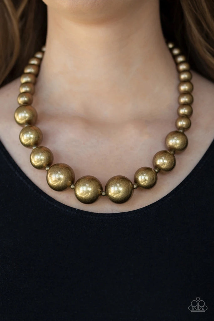 A collection of bold brass beads are threaded along an invisible wire below the collar. The antiqued beads dramatically increase in size as they reach the center for an undeniable statement-making finish. Features an adjustable clasp closure.  Sold as one individual necklace. Includes one pair of matching earrings.