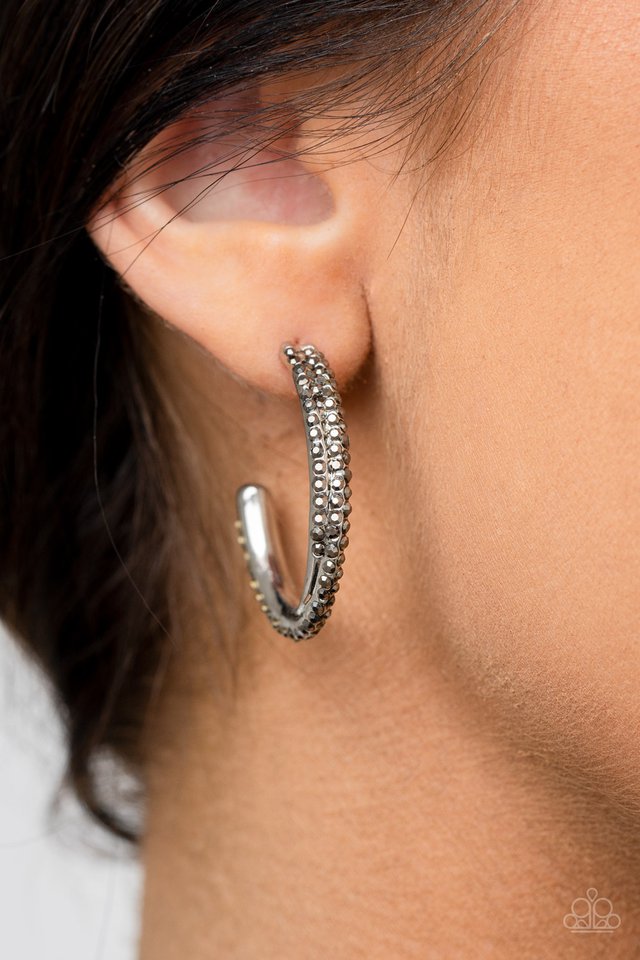 Two dainty rows of glittery hematite rhinestone encrusted silver bars delicately overlap and twist into a hook shaped hoop for a refined flair. Earring attaches to a standard post fitting. Hoop measures approximately 1" in diameter.  Sold as one pair of hoop earrings.