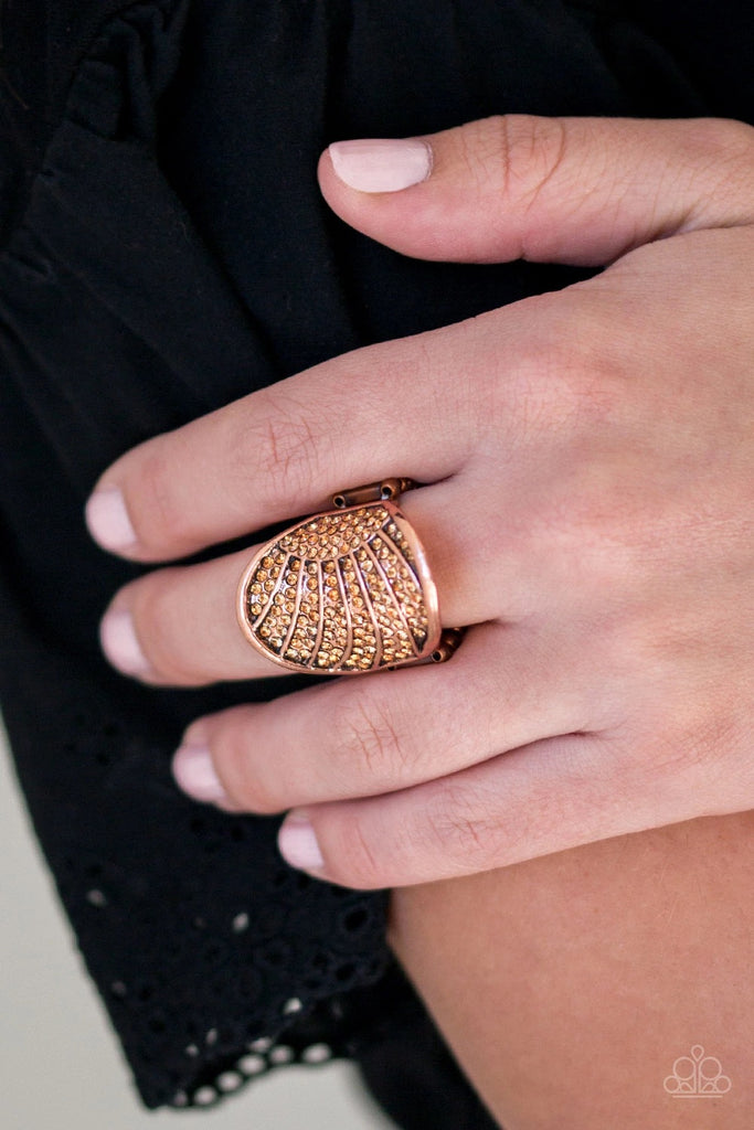 Radiating with copper linear textures, a circular copper frame is encrusted in countless topaz rhinestones as it folds around the finger for a timeless look. Features a stretchy band for a flexible fit.  Sold as one individual ring.