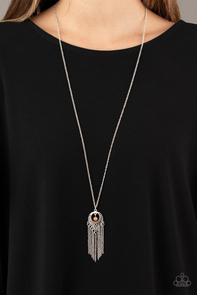 A vivacious orange stone bead swings from the top of an ornate silver frame. Infused with a tapered tassel, the whimsical pendant swings from the bottom of an elongated silver chain for a wanderlust finish. Features an adjustable clasp closure.  Sold as one individual necklace. Includes one pair of matching earrings.