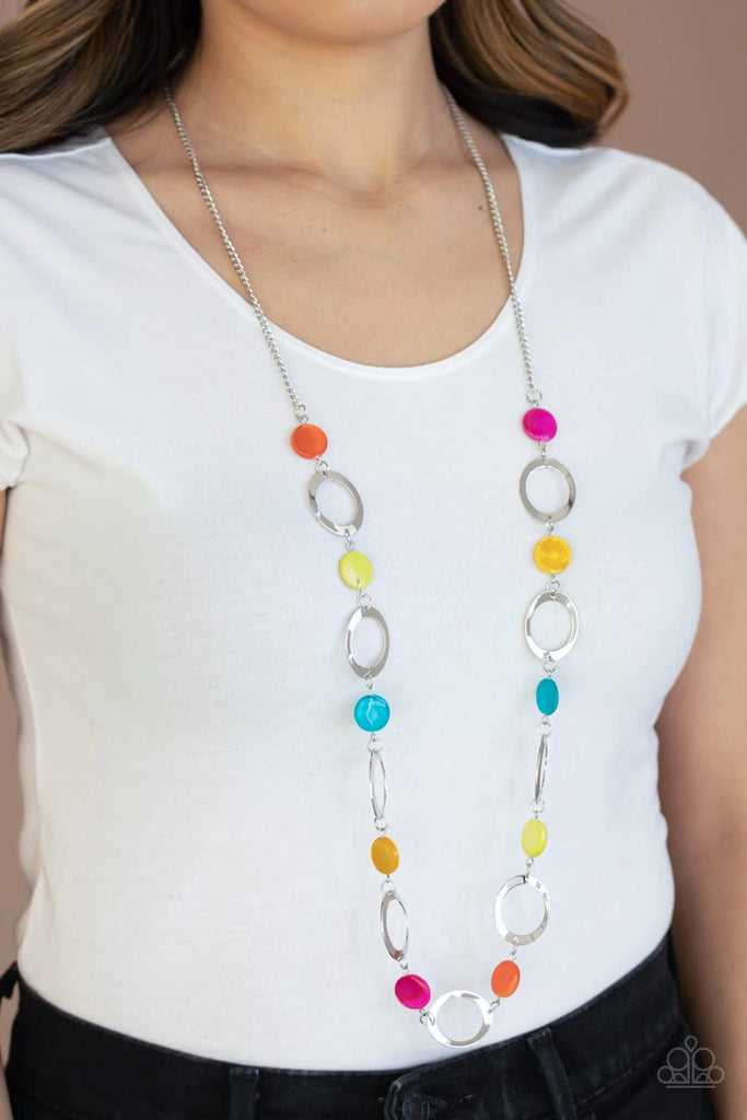 Multicolored shell-like beads and shimmery silver rings connect across the chest for a colorful summery look. Features an adjustable clasp closure.  Sold as one individual necklace. Includes one pair of matching earrings.