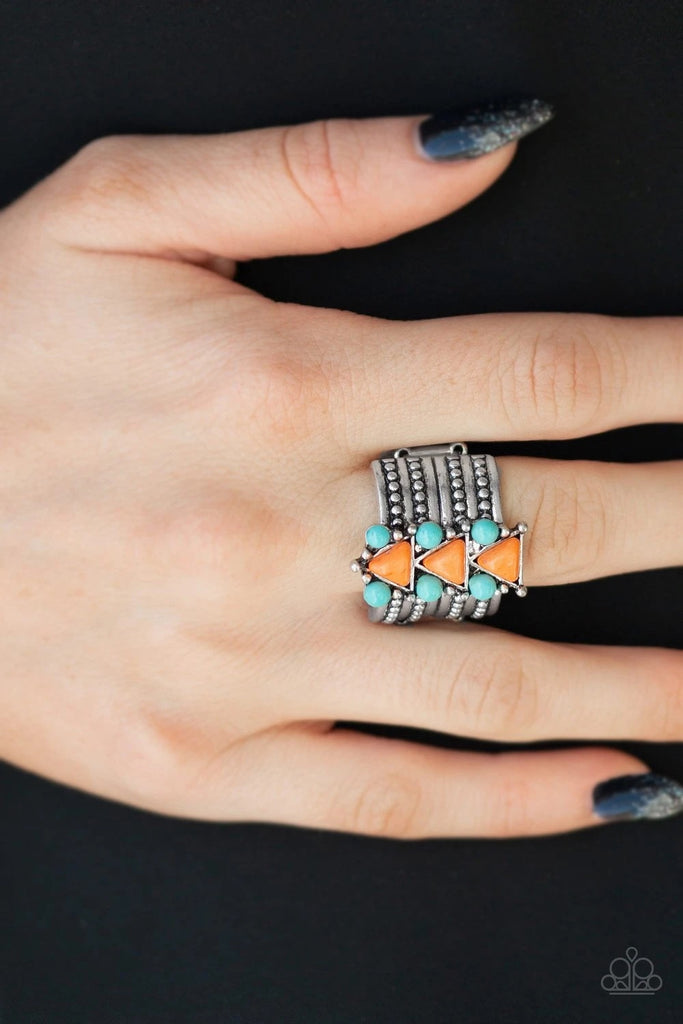 Round turquoise stones and orange triangular stones are pressed down the center of a thick silver band radiating with studded silver textures for an indigenous look. Features a stretchy band for a flexible fit.  Sold as one individual ring.