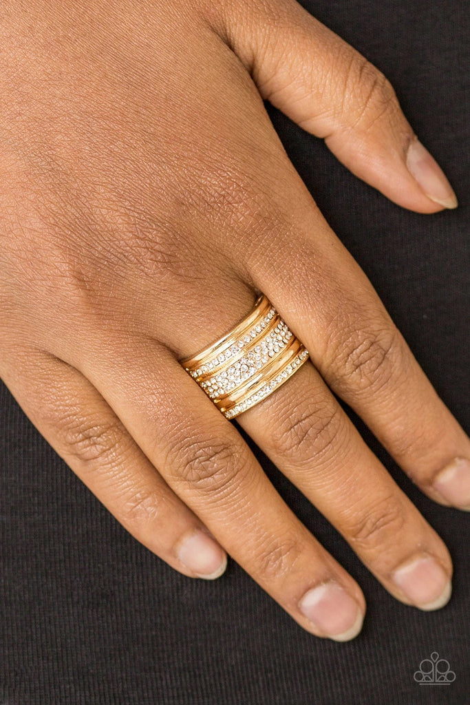 Shimmery gold and white rhinestone encrusted bands stack across the finger for a glamorous look. Features a stretchy band for a flexible fit.  Sold as one individual ring.