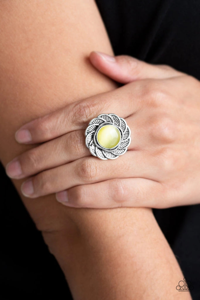 A glowing yellow moonstone is pressed into the center of a floral frame radiating with textured silver petals for a seasonal look. Features a stretchy band for a flexible fit.  Sold as one individual ring.