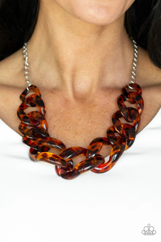 Featuring a tortoise shell finish, brown acrylic links gradually increase in size as they link below the collar in a statement-making fashion. Features an adjustable clasp closure.  Sold as one individual necklace. Includes one pair of matching earrings.