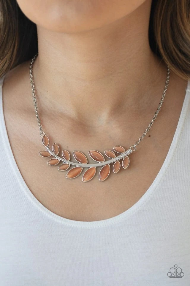 Dotted with tranquil orange cat's eye stones, a leafy silver branch delicately curves below the collar for a whimsical look. Features an adjustable clasp closure. Sold as one individual necklace. Includes one pair of matching earrings.