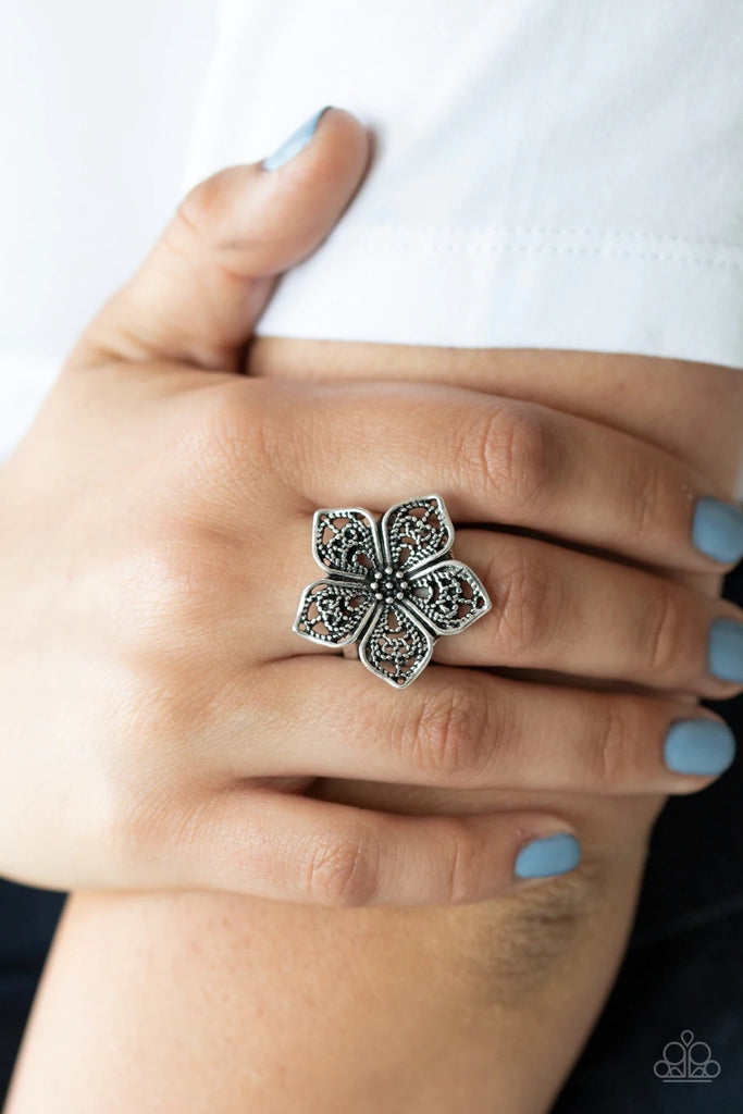 Brushed in an antiqued shimmer, lacy silver petals bloom from a studded center, creating a whimsical flower atop the finger. Features a stretchy band for a flexible fit.  Sold as one individual ring.