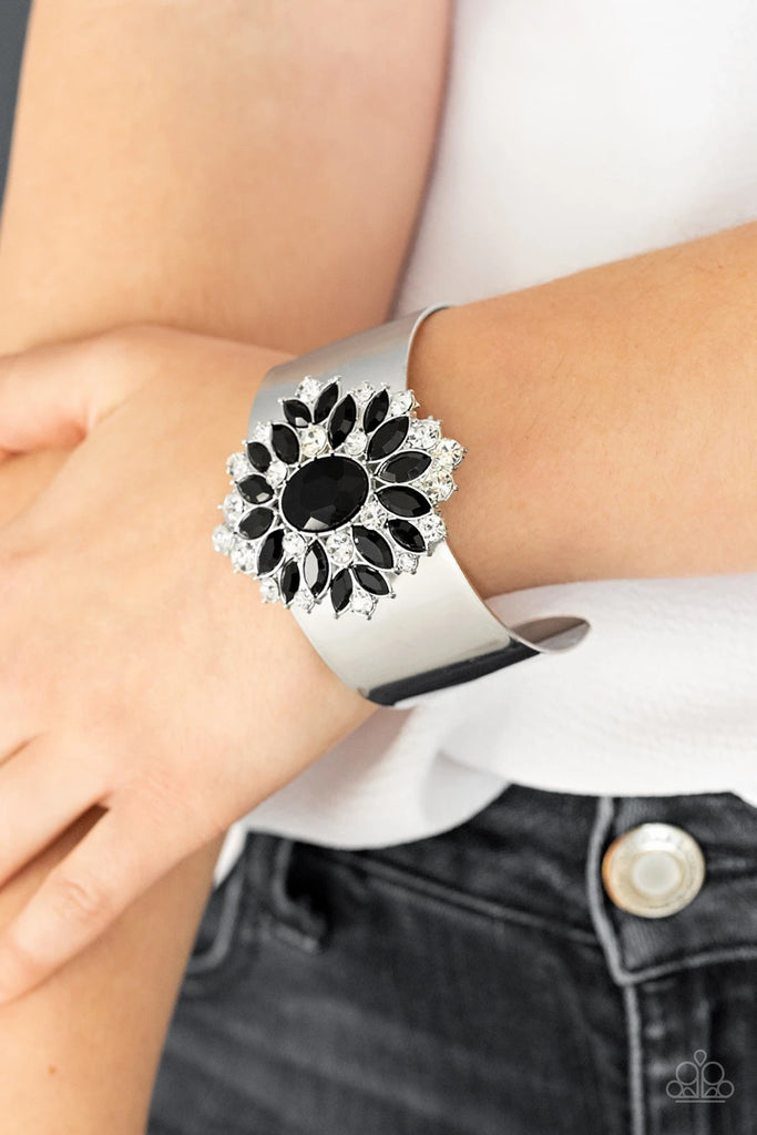 Featuring round and marquise style cuts, an explosion of sparkling black and white rhinestones flare from an oval black gem, creating a glamorous floral pendant atop a thick silver cuff.  Sold as one individual bracelet.