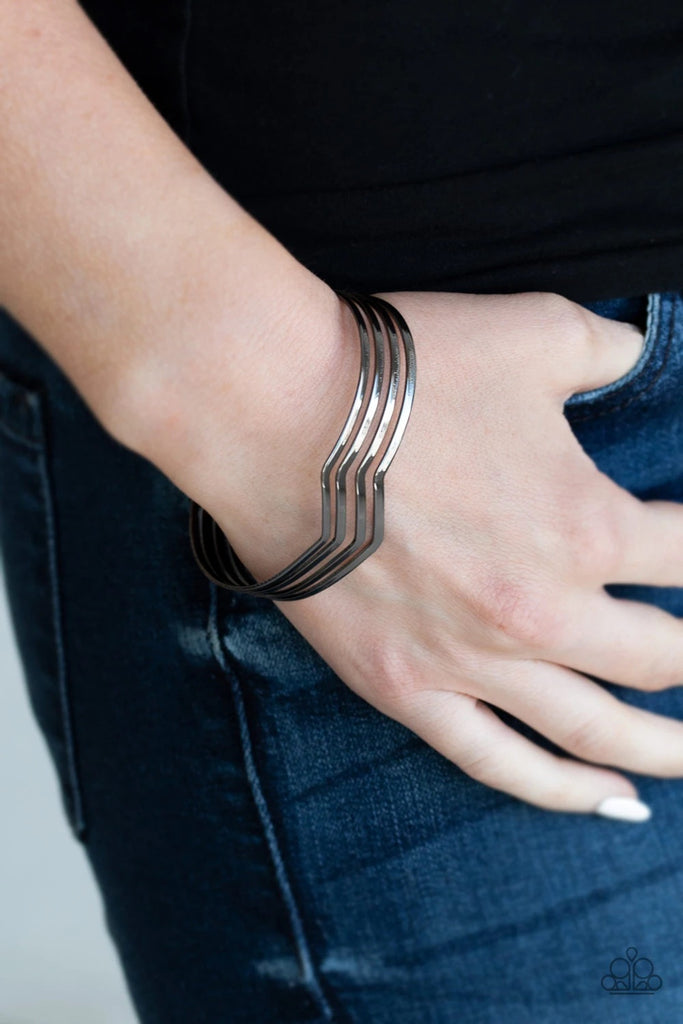 Glistening gunmetal bars zigzag across the wrist, coalescing into a wavy cuff.  Sold as one individual bracelet.
