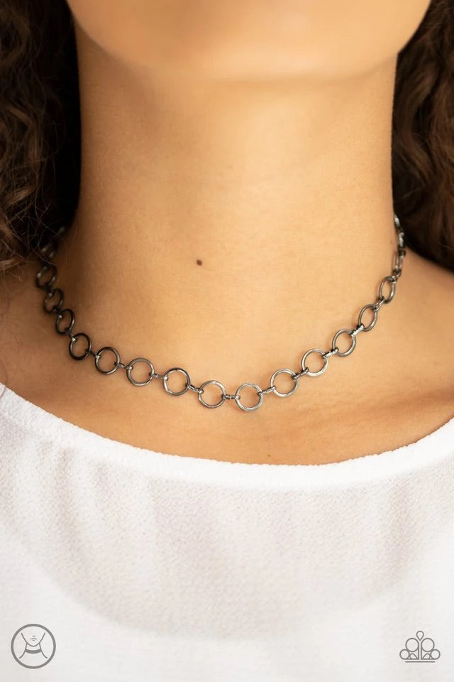 Dainty gunmetal rings link around the neck for a minimalist inspired shimmer. Features an adjustable clasp closure. Sold as one individual choker necklace. Includes one pair of matching earrings.  