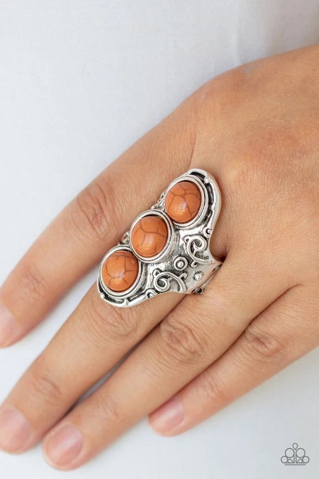 Three earthy brown stones are pressed down the center of an ornate silver frame embossed in swirling filigree for a seasonal look. Features a stretchy band for a flexible fit.  Sold as one individual ring.