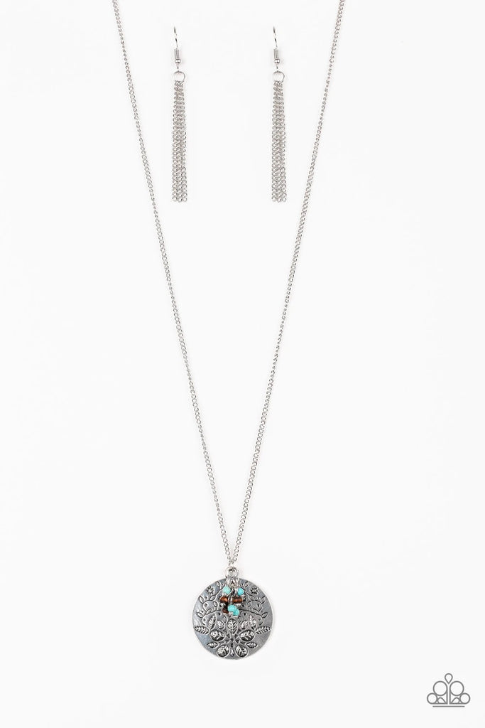A floral embossed silver disc and dainty wooden and turquoise stone beads swing from the bottom of a lengthened silver chain for a whimsical look. Features an adjustable clasp closure.  Sold as one individual necklace. Includes one pair of matching earrings.