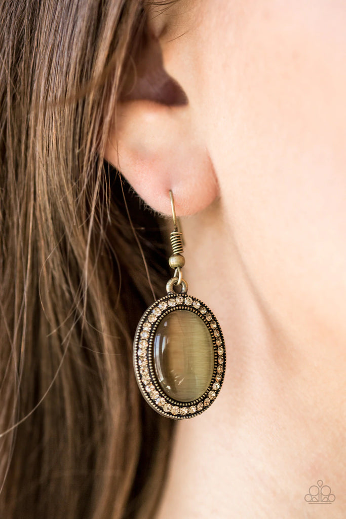 A brassy moonstone is pressed into the center of a topaz rhinestone encrusted frame for a whimsical look. Earring attaches to a standard fishhook fitting.  Sold as one pair of earrings.