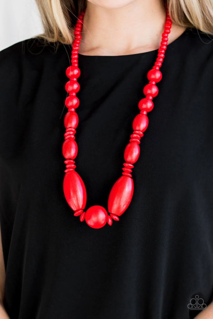 A variety of vivacious red wooden beads are threaded along a brown string draped across the chest for a summery flair.  Sold as one individual necklace. Includes one pair of matching earrings.