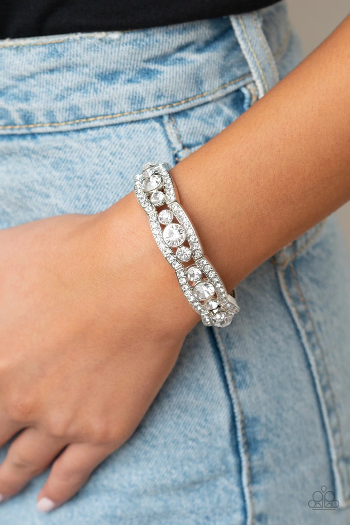 Rhinestone encrusted silver bars flank a dazzling trio of oversized white rhinestones, coalescing into a glittery frame. The sparkly frames are threaded along stretchy bands around the wrist, creating an irresistible shimmer.  Sold as one individual bracelet.