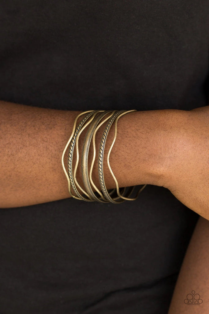 Stamped in tribal inspired patterns, round and wavy brass bangles stack across the wrist for a seasonal look.  Sold as one set of seven bracelets.