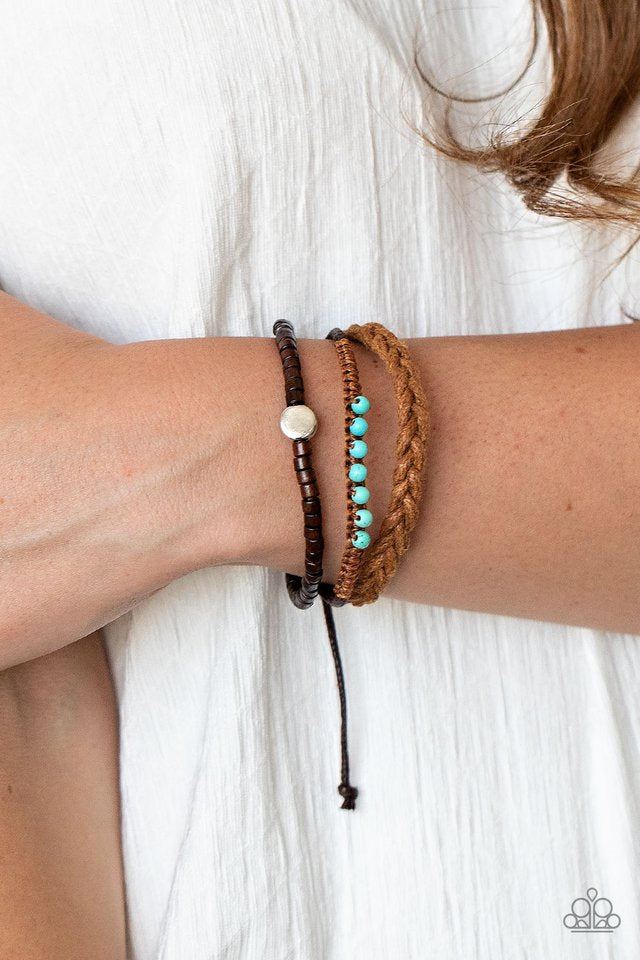 Mismatched strands of dainty wooden beads, turquoise stone beaded cording, and a braided cord layers around the wrist for a colorfully earthy look. Features an adjustable sliding knot closure.