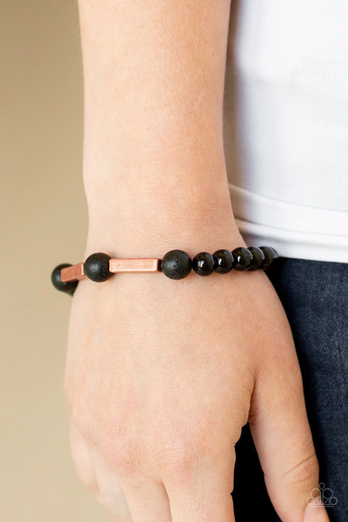 An earthy collection of rectangular copper accents, round black lava rock beads, and shiny black beads are threaded along a stretchy band around the wrist for a seasonal look.  Sold as one individual bracelet.