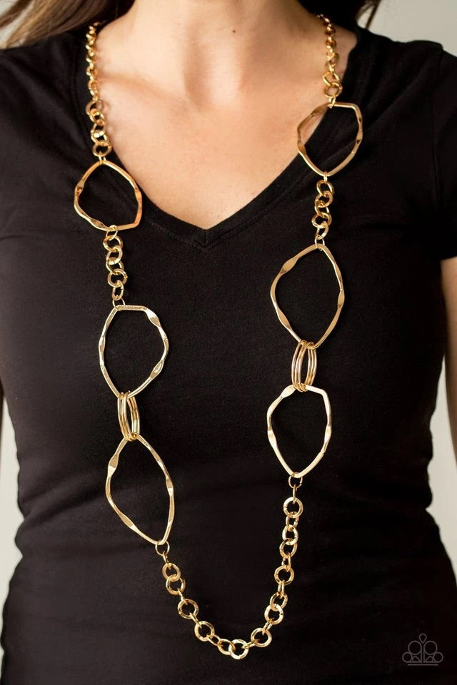 Mismatched sections of bold gold links, gold ovals, and flattened asymmetrical frames link across the chest for an abstract look. Features an adjustable clasp closure.  Sold as one individual necklace. Includes one pair of matching earrings.