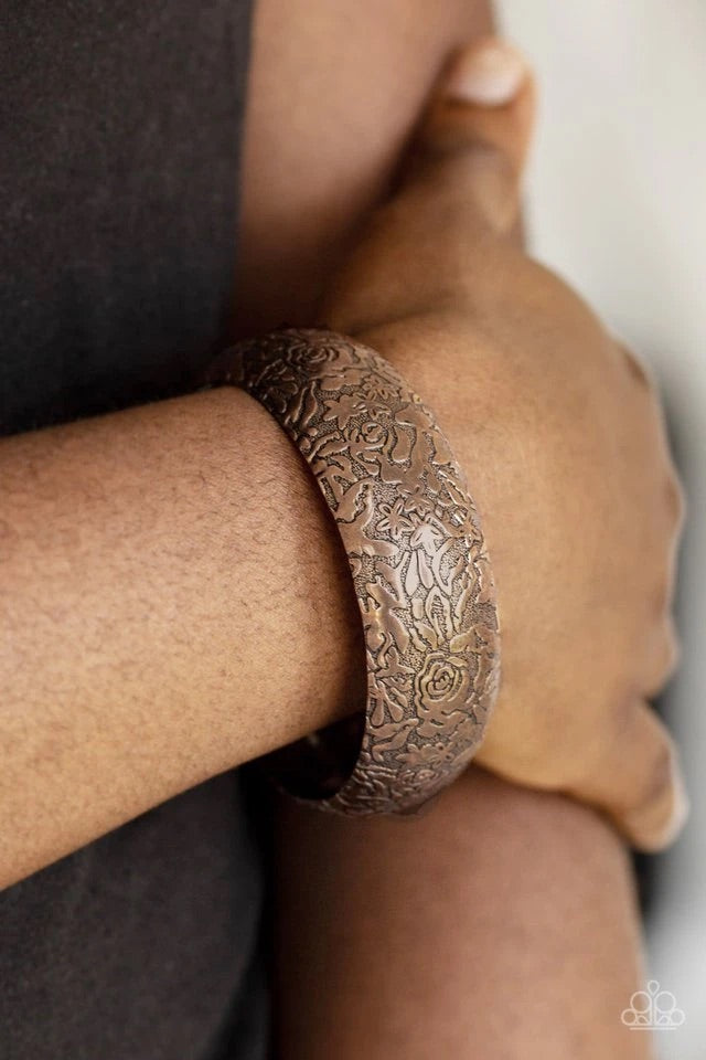 Brushed in an antiqued finish, a rosy floral pattern is embossed across a thick copper bangle for a seasonal flair.  Sold as one individual bracelet.