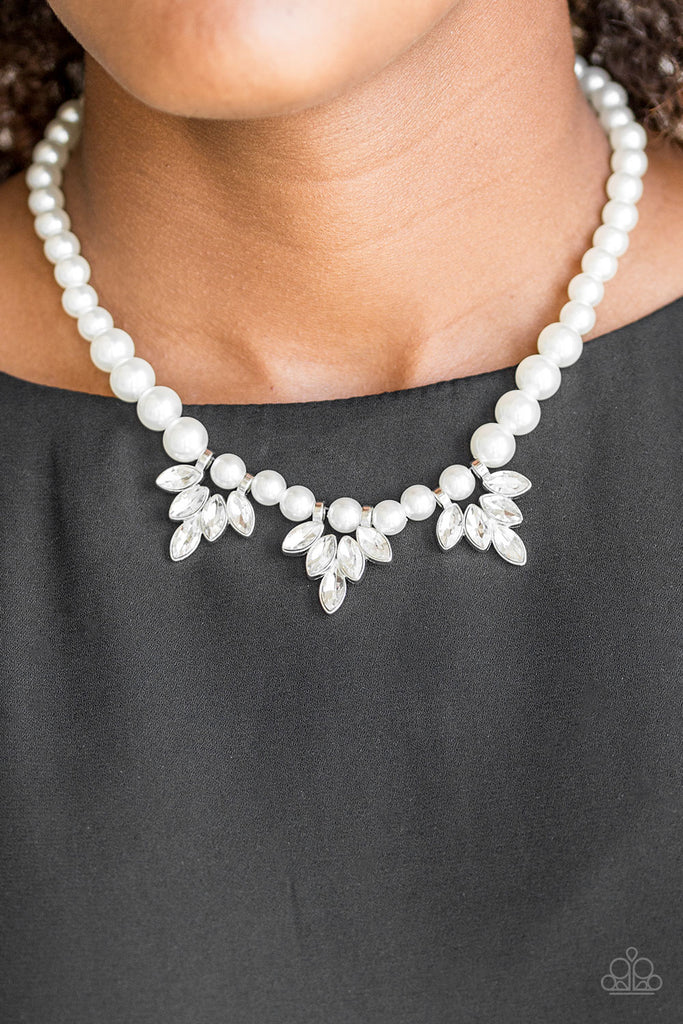 A strand of classic white pearls drapes elegantly below the collar. Featuring regal marquise style cuts, glittery white rhinestone frames swing from the pearls for a timeless finish. Features an adjustable clasp closure.  Sold as one individual necklace. Includes one pair of matching earrings.