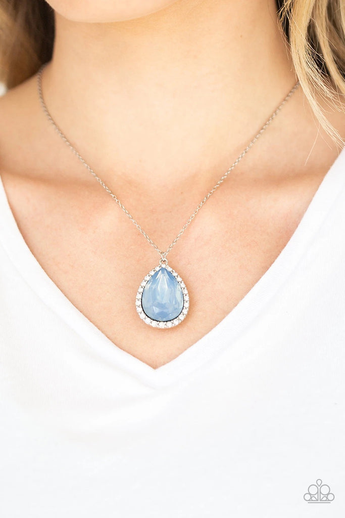 Featuring an iridescent finish, a dramatic blue teardrop gem is pressed into a shimmery silver frame radiating with glassy white rhinestones. The glamorous pendant swings from the bottom of a dainty silver chain below the collar for a timeless finish. Features an adjustable clasp closure.  Sold as one individual necklace. Includes one pair of matching earrings.