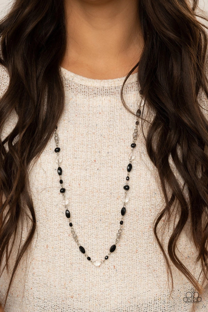 A refined collection of imperfectly shaped black beads, studded silver accents, and opalescent crystal-like beads drape across the chest, creating an elegant display. Features an adjustable clasp closure.  Sold as one individual necklace. Includes one pair of matching earrings.