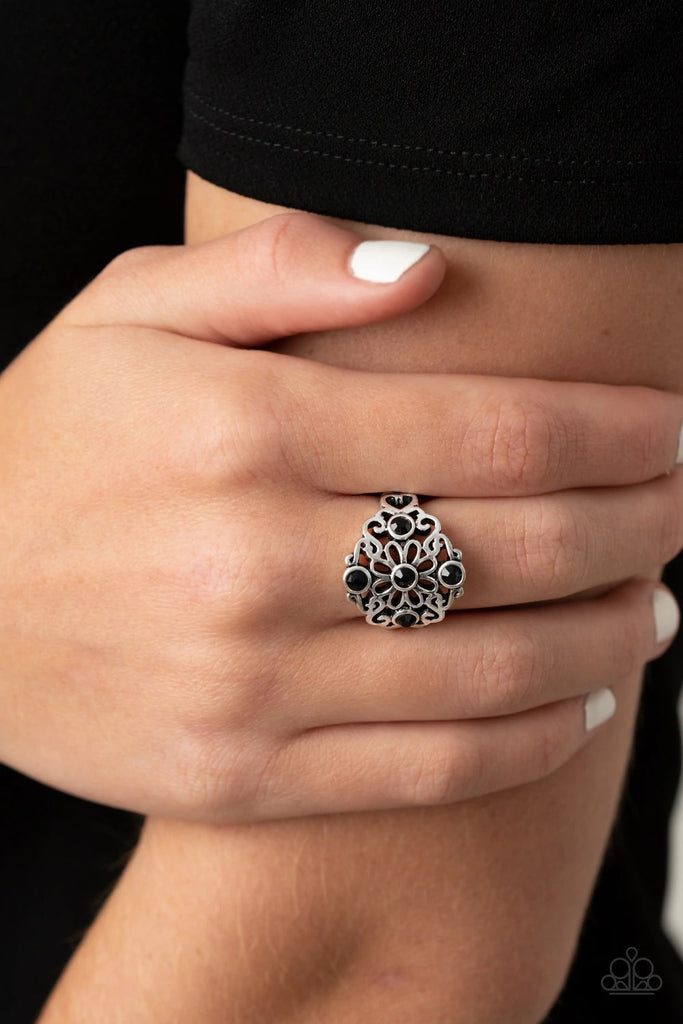 Dotted with glittery black rhinestones, glistening silver filigree blooms into a whimsical floral centerpiece atop the finger. Features a stretchy band for a flexible fit.  Sold as one individual ring.