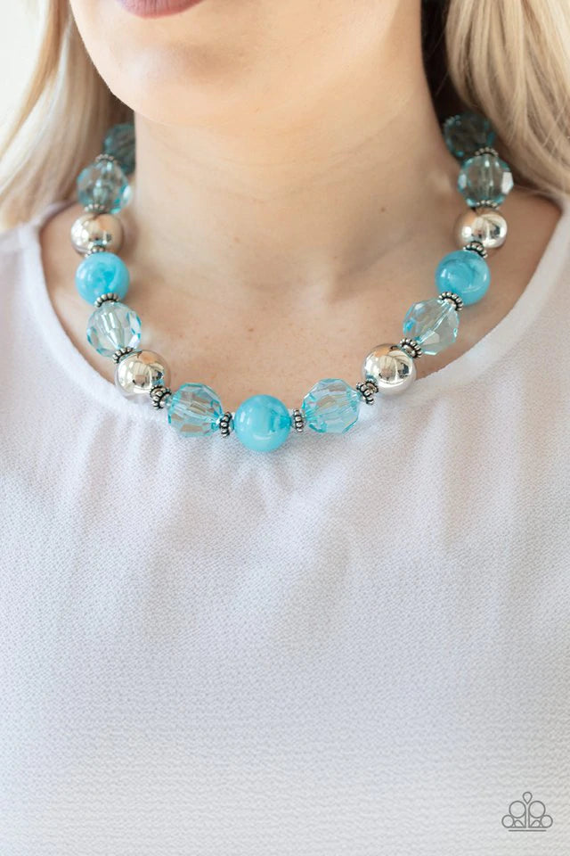 Infused with dainty silver accents, an exaggerated display of oversized silver beads, faceted blue crystal-like beads, and cloudy blue beads are threaded along an invisible wire below the collar for a colorfully statement-making fashion. Features an adjustable clasp closure. Sold as one individual necklace. Includes one pair of matching earrings.