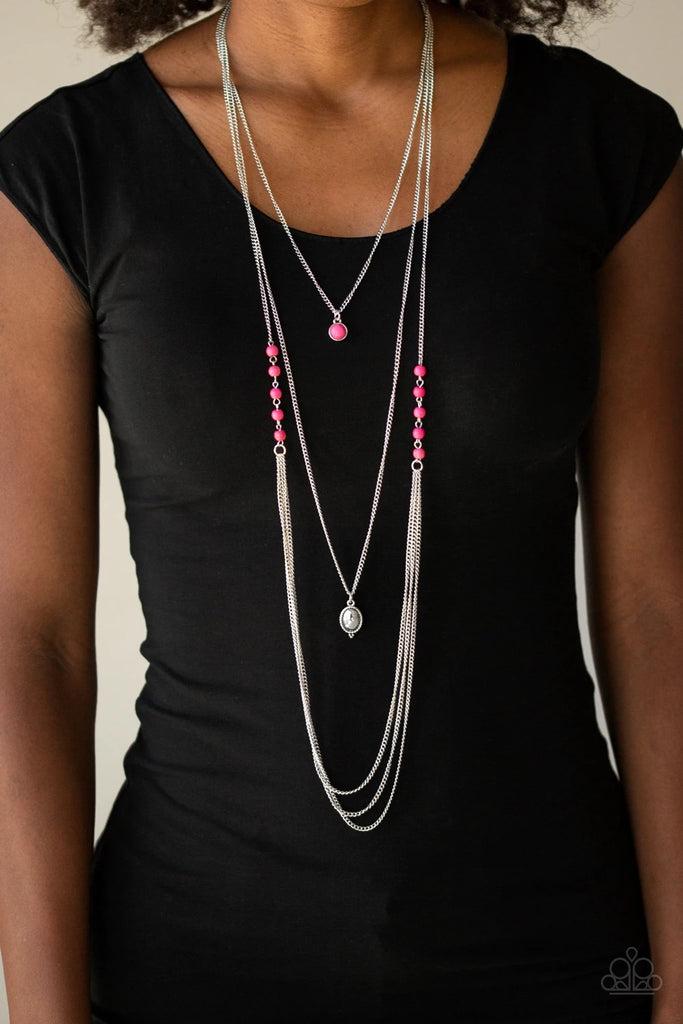 Infused with pink stone beads give way to layers of shimmery silver chain down the chest. A pink stone pendant and shiny silver frame drape above the cascade of silver chains for a seasonal flair. Features an adjustable clasp closure.  Sold as one individual necklace. Includes one pair of matching earrings.