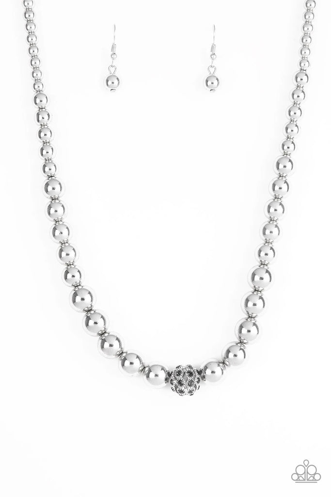 Gradually increasing in size near the center, glistening silver beads are threaded along an invisible wire below the collar. Encrusted in smoky rhinestones, a sparkling silver bead adorns the center for a refined finish. Features an adjustable clasp closure.  Sold as one individual necklace. Includes one pair of matching earrings.