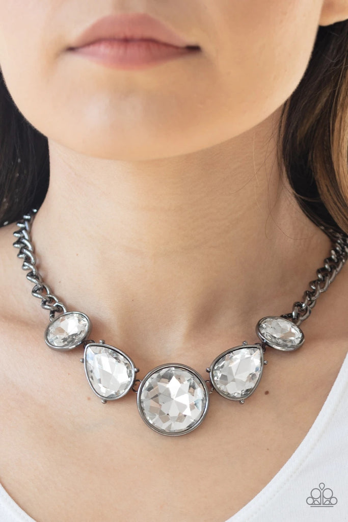 Infused with a heavy gunmetal chain, an exaggerated display of round and teardrop-shaped white rhinestones connect below the collar for a blinding look. Features an adjustable clasp closure.  Sold as one individual necklace. Includes one pair of matching earrings.  