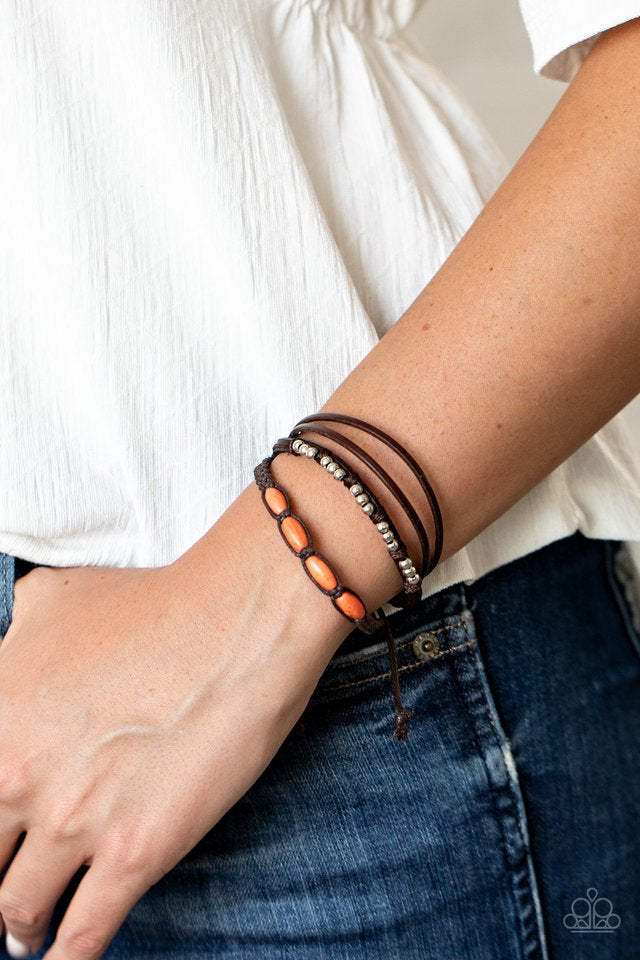 Infused with dainty silver and refreshing orange stone beads, mismatched strands of braided twine-like cord and brown leather pieces delicately layer across the wrist for a colorfully earthy look. Features an adjustable sliding knot closure.  Sold as one individual bracelet.  