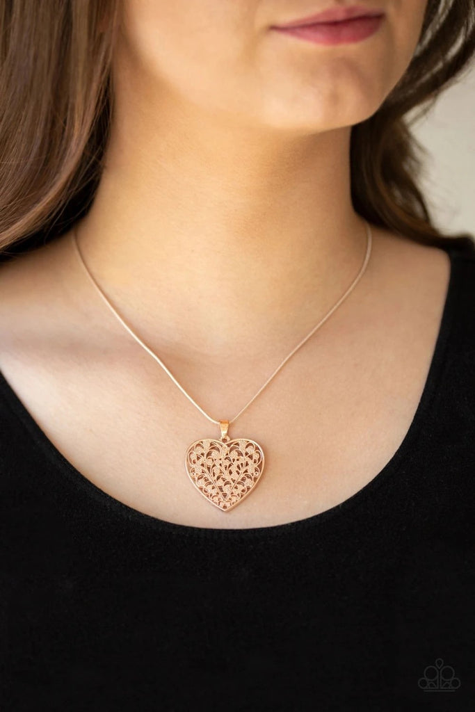 Filled with vine-like filigree detail, a rose gold heart pendant swings below the collar for a vintage inspired look. Features an adjustable clasp closure.  Sold as one individual necklace. Includes one pair of matching earrings.