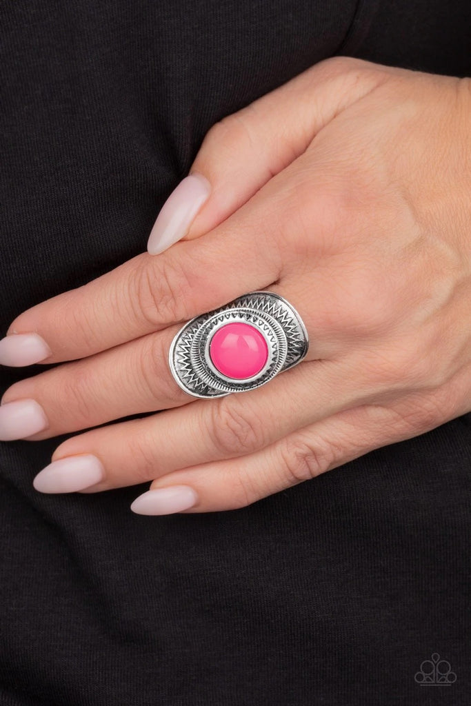A neon pink bead is pressed into the center of a stacked silver frame radiating with sunburst patterns, creating a flamboyant centerpiece. Features a stretchy band for a flexible fit.  Sold as one individual ring.