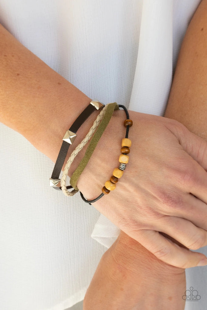 Infused with mismatched metal and wooden accents, rows of green and brown suede and leather cords layer across the wrist for a rugged look. Features an adjustable sliding knot closure.  Sold as one individual bracelet.
